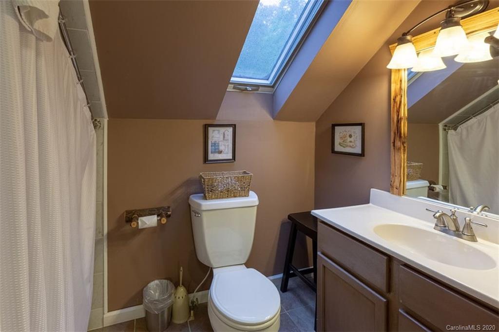 136 Dars Lane Tuckasegee, NC 28783 - Photo 21 of 48 a bathroom with a toilet a sink and mirror