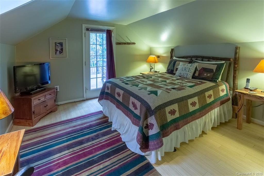 136 Dars Lane Tuckasegee, NC 28783 - Photo 22 of 48 a bedroom with bed and a flat tv screen on dresser