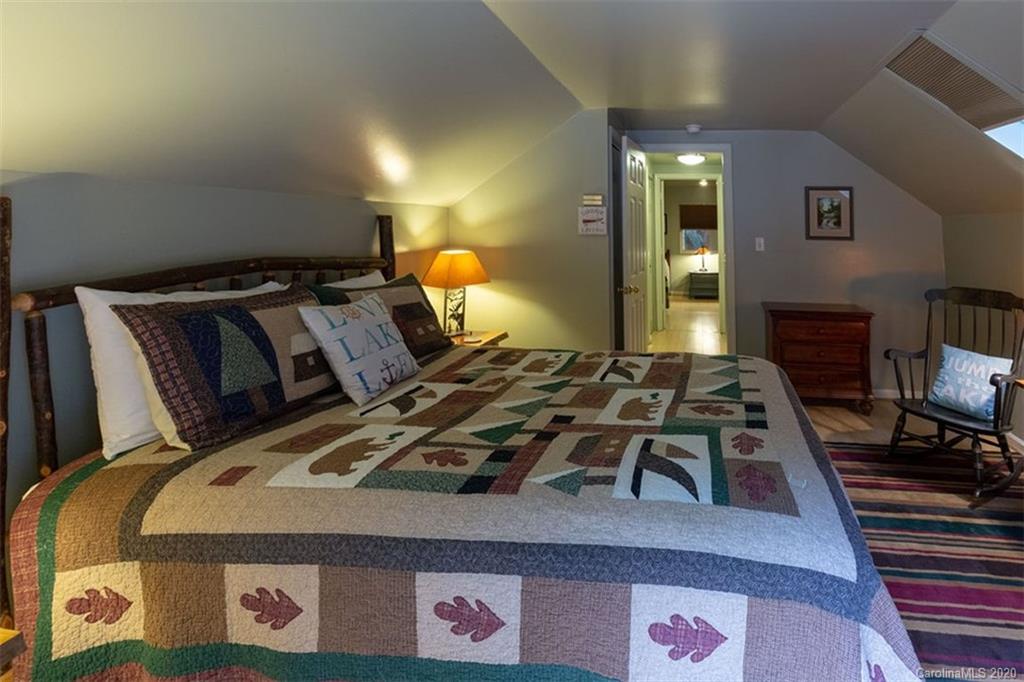 136 Dars Lane Tuckasegee, NC 28783 - Photo 23 of 48 a bed sitting in a bedroom next to a lamp