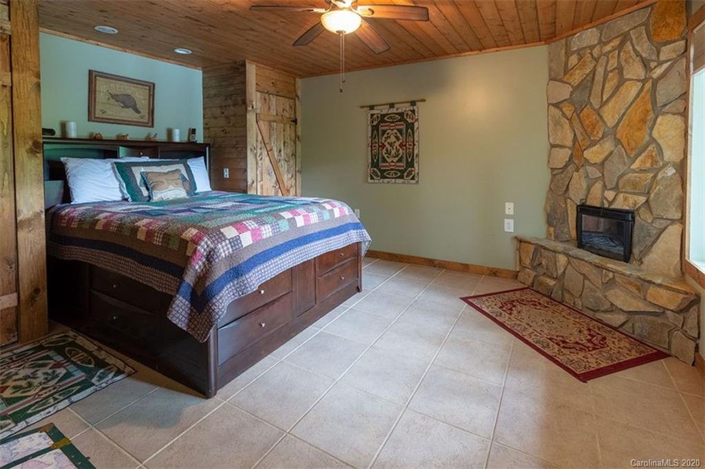 136 Dars Lane Tuckasegee, NC 28783 - Photo 28 of 48 a bedroom with a bed and a fireplace