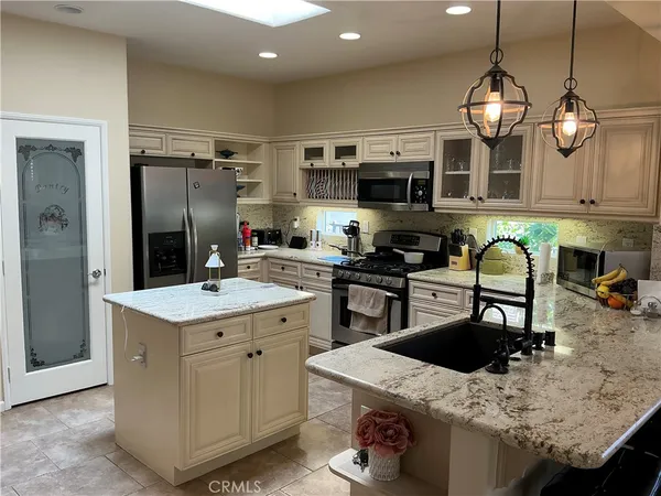 a kitchen with stainless steel appliances granite countertop a sink a stove and a refrigerator