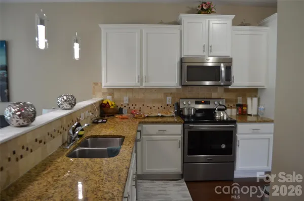 a kitchen with stainless steel appliances granite countertop a sink and a stove