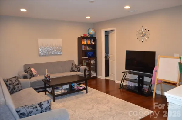 a living room with furniture and a wooden floor