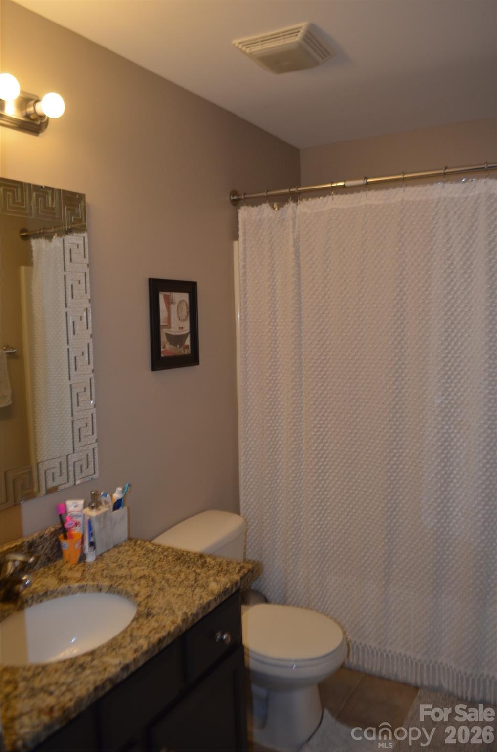 4549 Tradd Circle Monroe, NC 28110 - Photo 28 of 33 a bathroom with a granite countertop sink toilet and a mirror