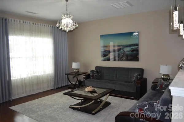 a living room with furniture and a chandelier