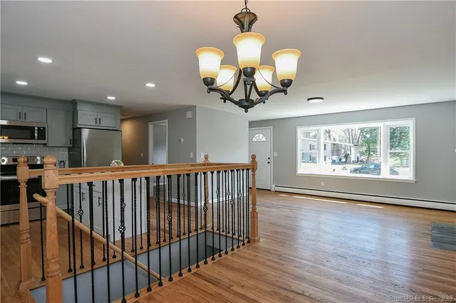 a view of a room with wooden floor fan and windows
