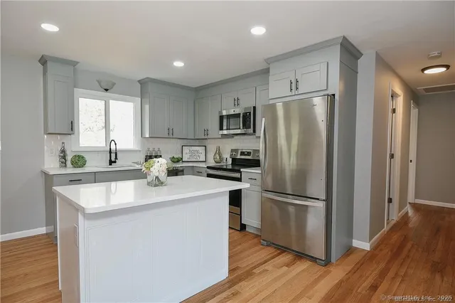 a kitchen with kitchen island stainless steel appliances a refrigerator sink and microwave