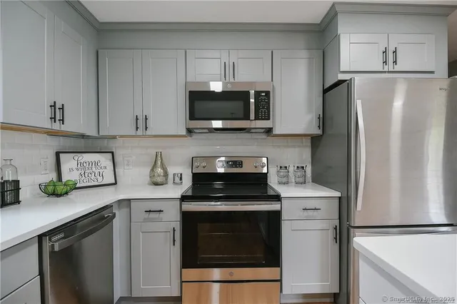a kitchen with stainless steel appliances a stove microwave and refrigerator