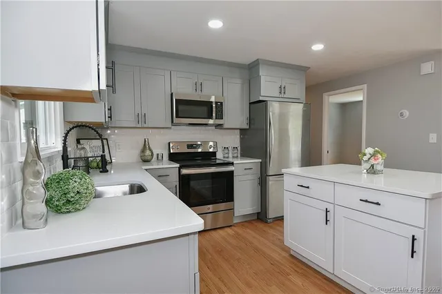 a kitchen with white cabinets and stainless steel appliances