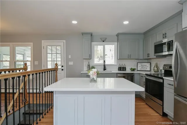 a kitchen with stainless steel appliances a sink stove microwave and cabinets