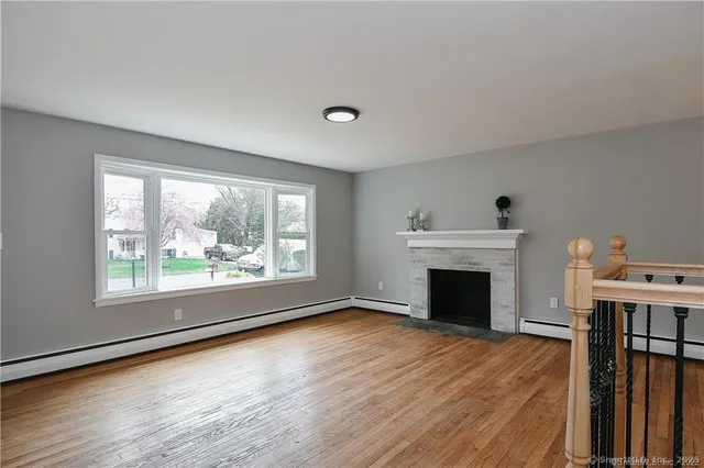 an empty room with fireplace wooden floor and windows