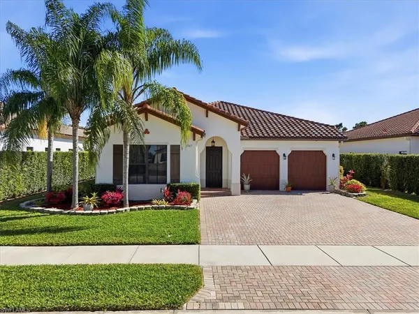 a front view of a house with a yard and potted plants