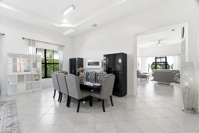 a dining room with furniture and large windows