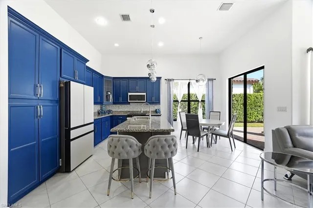 a dining room with furniture a large window and stainless steel appliances