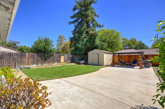 a view of backyard with outdoor seating and trees