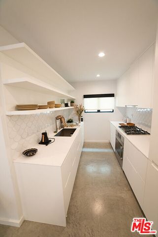 a kitchen with kitchen island white cabinets and white appliances