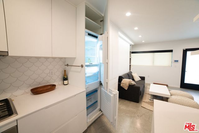 a kitchen with a refrigerator and a stove top oven