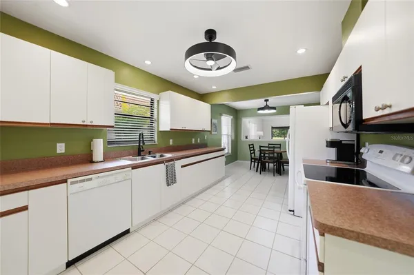 a kitchen with stainless steel appliances granite countertop a sink and a white cabinets