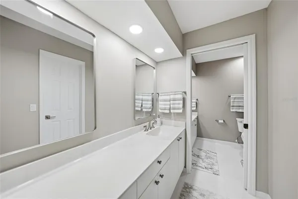 a spacious bathroom with a shower sink and mirror