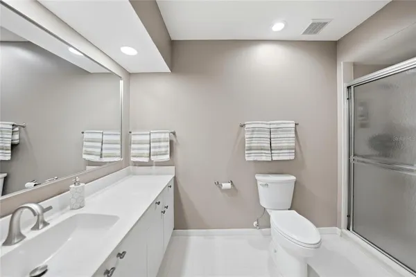 a bathroom with a sink a toilet a mirror and shower