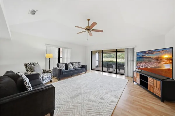 a living room with furniture tv and a floor to ceiling window