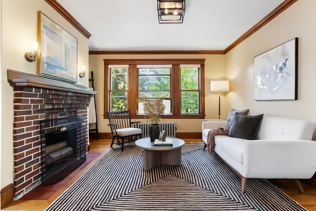 a living room with furniture a fireplace and a large window