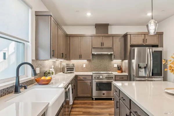 a kitchen with stainless steel appliances a sink stove and refrigerator