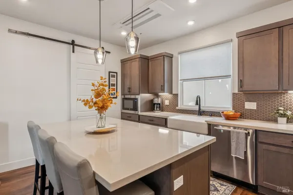a kitchen with stainless steel appliances a sink a table and chairs