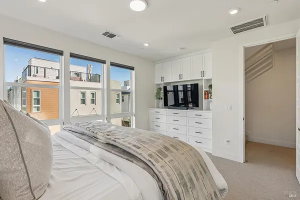 a spacious bedroom with a bed and a television