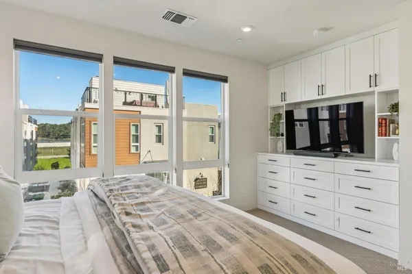 a bedroom with a bed and a large window