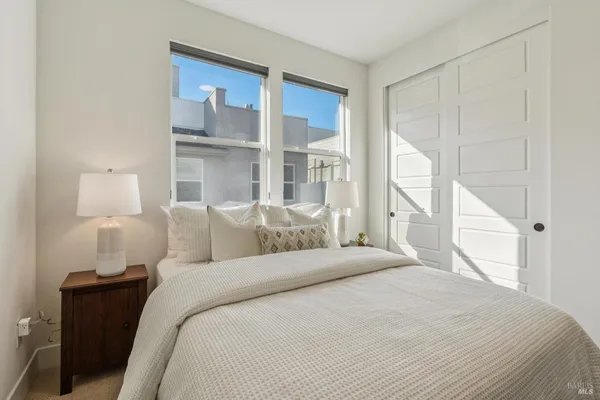 a bedroom with a large bed and a lamp on table