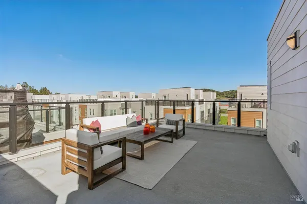 a roof deck with table and chairs