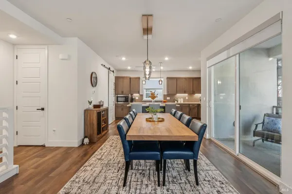 a kitchen with a table chairs refrigerator and microwave