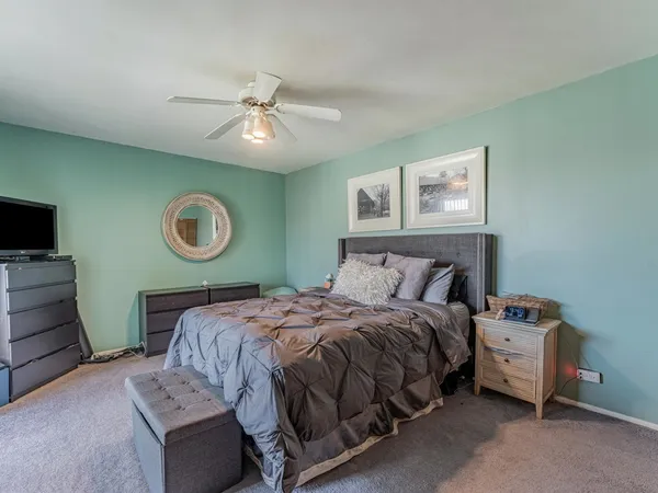 a bed sitting in a spacious bedroom next to a window