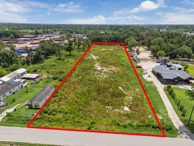 an aerial view of residential houses with outdoor space and trees