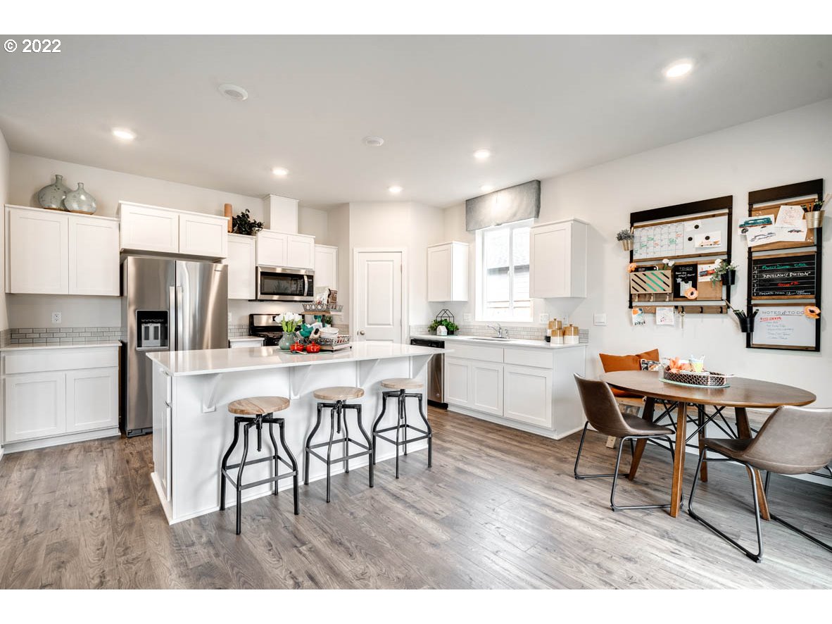 2935 Fenya Street Springfield, OR 97477 - Photo 8 of 20 a kitchen with a dining table chairs appliances and wooden floor