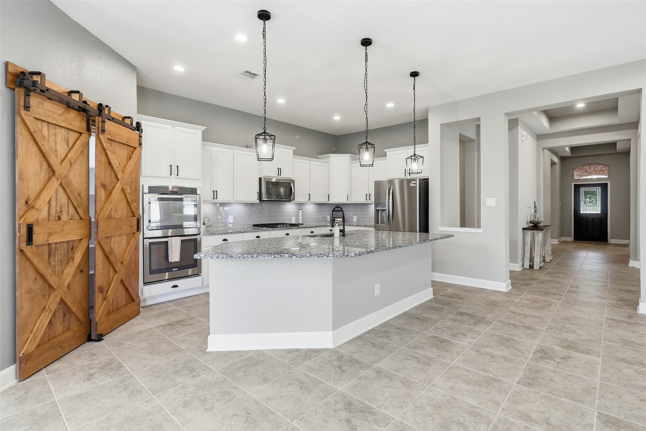 24126 Cane Fields Road Katy, TX 77493 - Photo 11 of 36 Elegant kitchen designed for everyday living and entertaining, and a custom walk-in pantry with a distinctive sliding barn door.