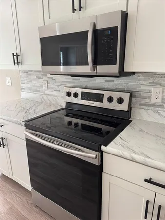 a stove top oven sitting inside of a kitchen