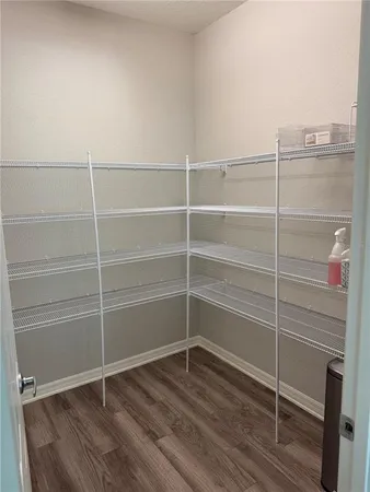 a view of an empty room with wooden floor and vanity
