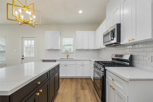 a kitchen with stainless steel appliances granite countertop a sink stove and cabinets