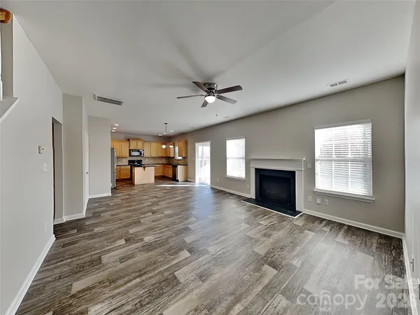 a view of an empty room with a fireplace and a window