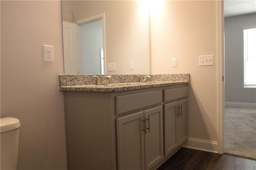 6120 Ripple Way, Unit 46 Atlanta, GA 30349 - Photo 15 of 19 a bathroom with a granite countertop sink and a mirror