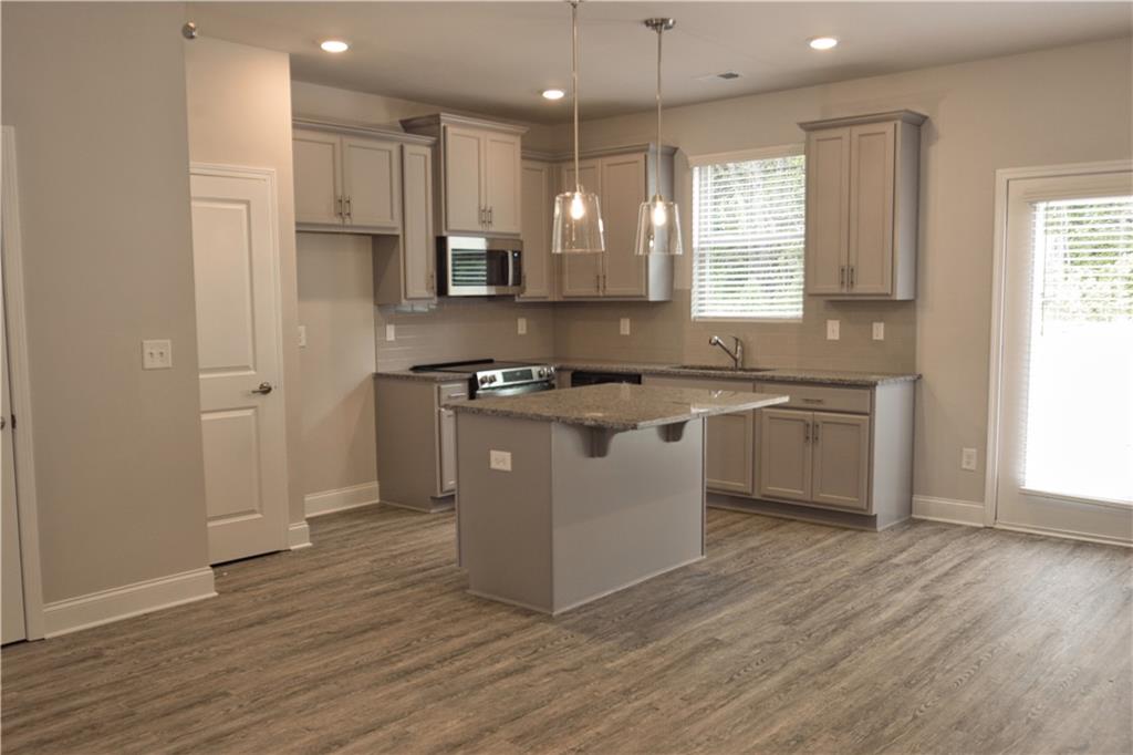 6120 Ripple Way, Unit 46 Atlanta, GA 30349 - Photo 7 of 19 a large kitchen with stainless steel appliances granite countertop a stove a sink and a microwave