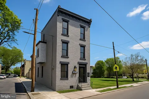 a view of a brick house with a yard next to a road