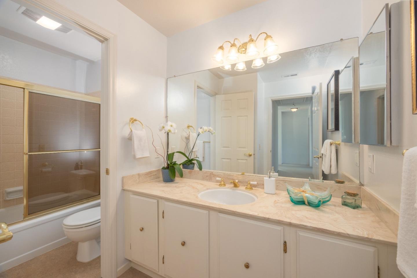 21 Pinehurst Lane Half Moon Bay, CA 94019 - Photo 29 of 43 a bathroom with a sink a toilet and a large mirror