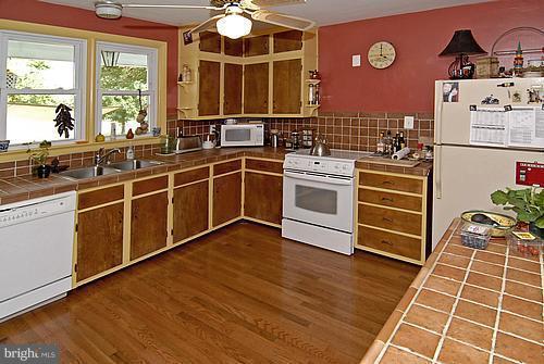 1700 Ednor Road Silver Spring, MD 20905 - Photo 12 of 18 a kitchen with stainless steel appliances a stove a sink and white cabinets with wooden floor