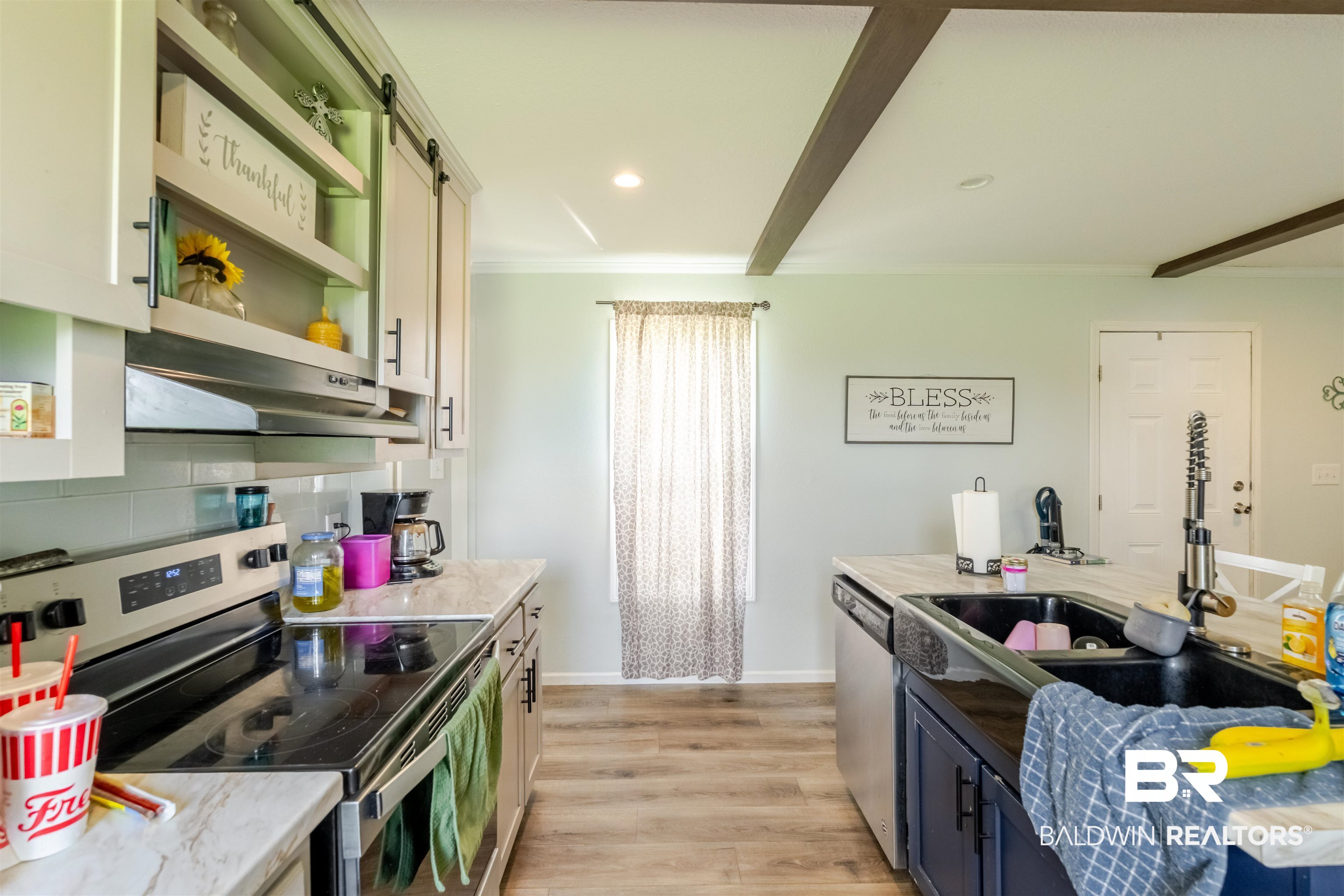 15575 Mikkelsen Road Summerdale, AL 36580 - Photo 11 of 68 Kitchen featuring light wood-finish flooring, light cabinetry with open shelving, dark beam accents on the ceiling, a built-in dishwasher, and a stainless steel range with a built-in hood