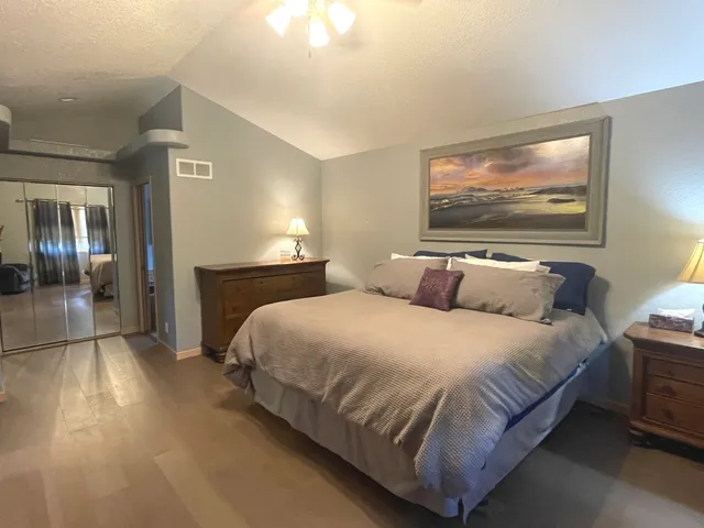 a bedroom with a bed and painting on the wall