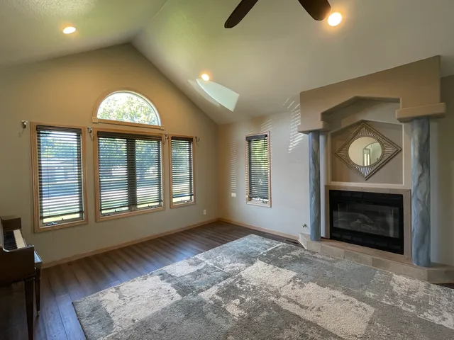 an empty room with windows cabinet and fireplace