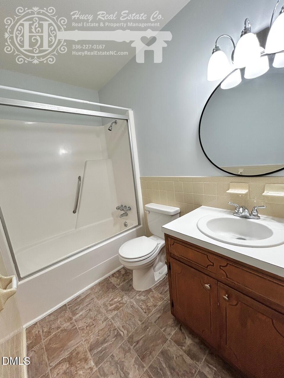296 Seventh Avenue, Unit 3 Yanceyville, NC 27379 - Photo 19 of 21 a bathroom with a toilet a sink and mirror